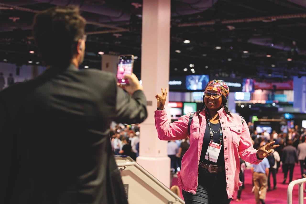 A woman posing for a photo at a conference
