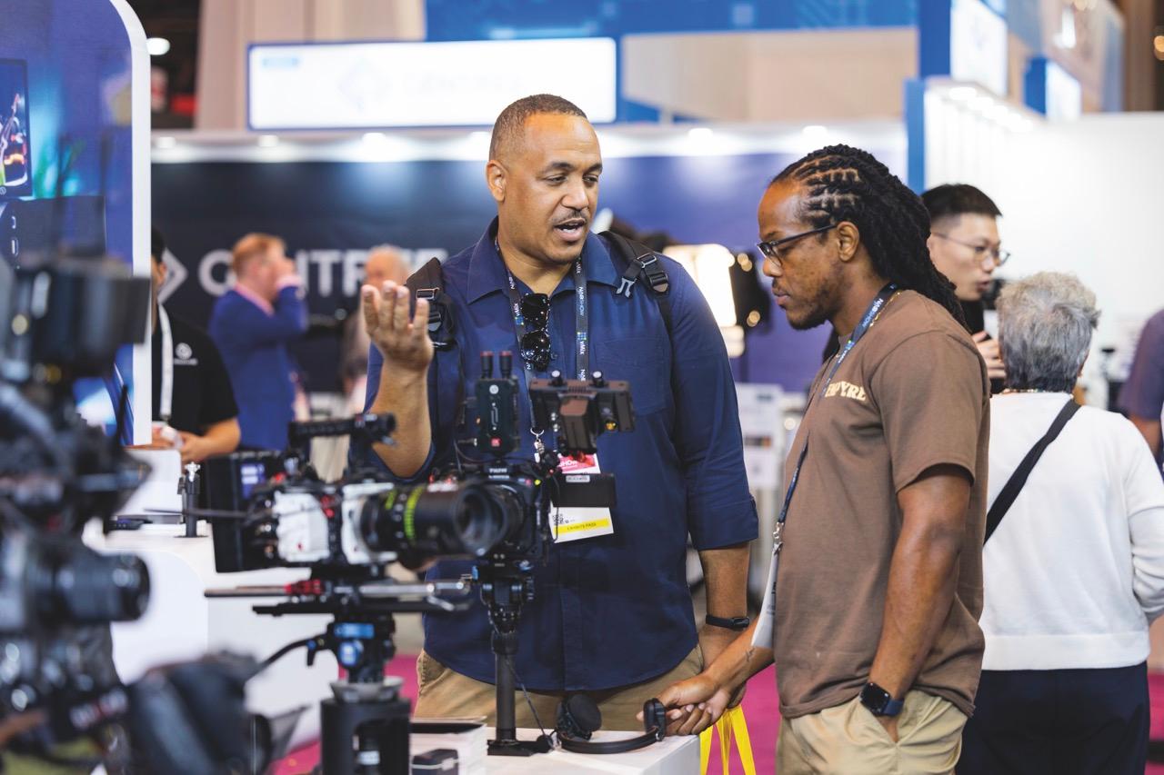 Two men looking at camera equipment at NAB Show 2025