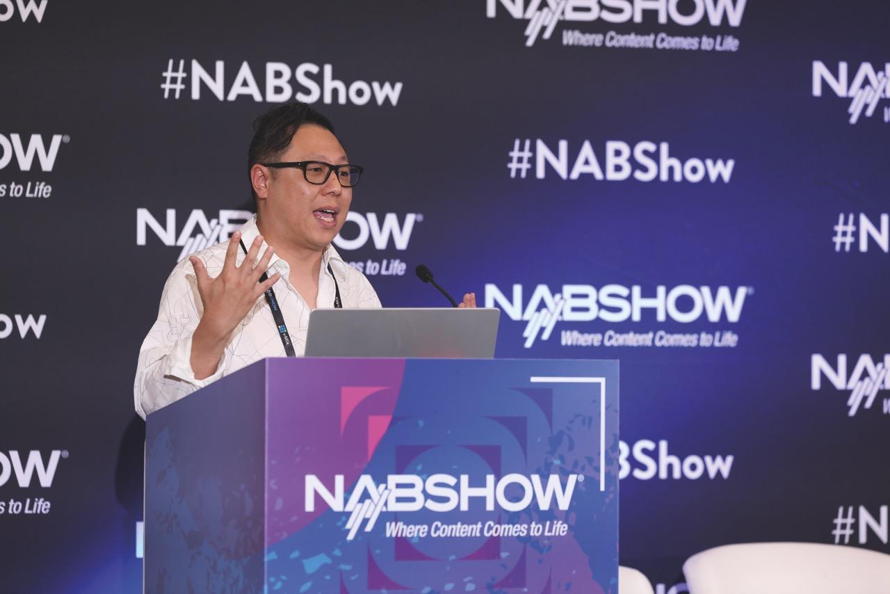 A person giving a presentation at NAB Show 2025 standing behind a podium
