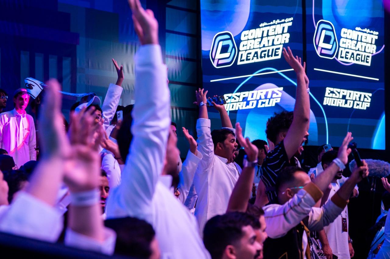 A crowd cheering at the Esports World Cup