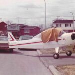 Vintage picture of a small airplane parked on a driveway