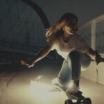 Girl crouched on a skateboard at night