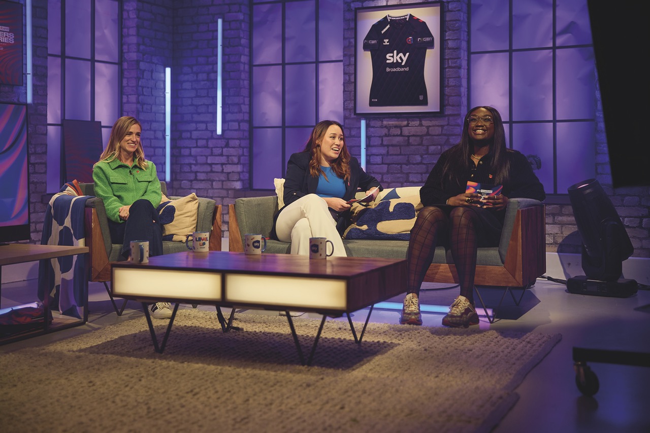 Three women sitting on couches during a talk show